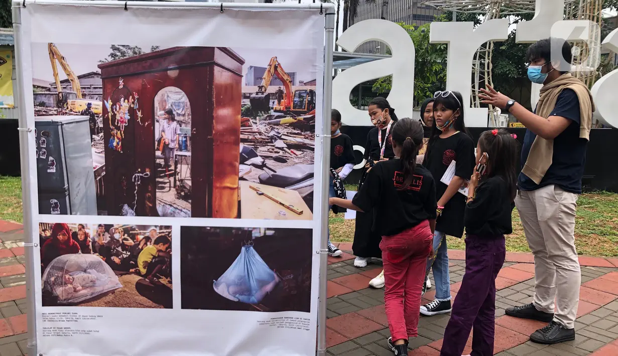 Komunitas “Kelas Jurnalis Cilik” dipandu pewarta foto mengikuti kegiatan tur pameran fotografi bertema 'Ragam Cerita Ibu Kota Sebelum dan Saat Pandemi COVID-19' di Thamrin 10, Jakarta, Minggu (6/12/2020). Pameran tersebut berlangsung hingga 13 Desember 2020. (Liputan6.com/Immanuel Antonius)