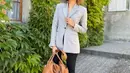 Tampil stylish dengan outfit kasual, Donna Agnesia memadukan blazer, celana panjang, dan sneakers putih. Ditambah tas berwarna coklat muda. (Instagram/dagnesia).