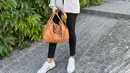 Tampil stylish dengan outfit kasual, Donna Agnesia memadukan blazer, celana panjang, dan sneakers putih. Ditambah tas berwarna coklat muda. (Instagram/dagnesia).