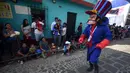 Anggota Saturno Club dengan kostum Dick Dastardly melakukan parade Dance of Costumes tahunan di sepanjang jalan kota Sumpango, Guatemala, Senin (30/12/2019). Parade kostum yang menampilkan karakter televisi dan film ini untuk memeriahkan malam pergantian tahun. (ORLANDO ESTRADA/AFP)