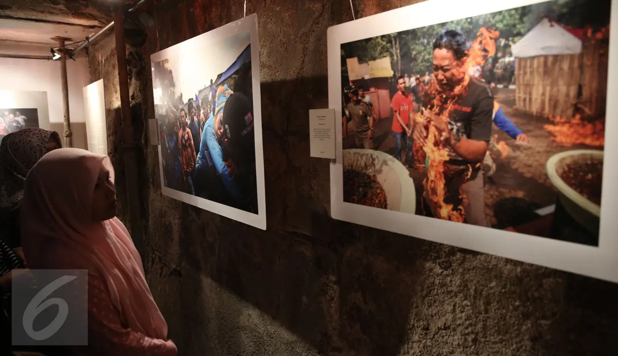 Pengunjung mengamati foto saat pameran foto Anugerah Pewarta Foto Indonesia (APFI) ke-VI di Gedung Bandung, Sabtu (9/4). APFI 2016 memamerkan 25 foto tunggal dan tiga foto seri terbaik sepanjang tahun 2015. (Liputan6.com/Faizal Fanani)