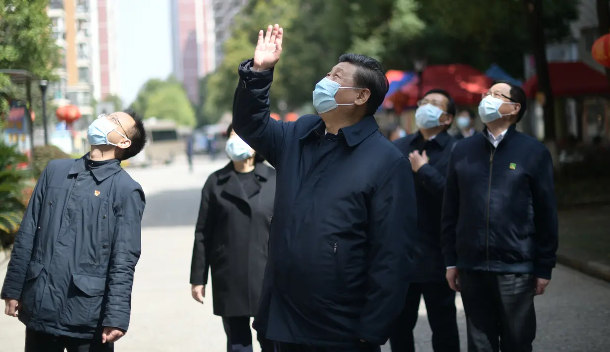 Presiden China Xi Jinping melambaikan tangan kepada warga yang dikarantina di rumah serta menyampaikan salam kepada mereka di sebuah area permukiman di Wuhan, 10 Maret 2020. Xi melakukan inspeksi terkait upaya pencegahan dan pengendalian wabah virus corona di Wuhan. (Xinhua/Xie Huanchi)