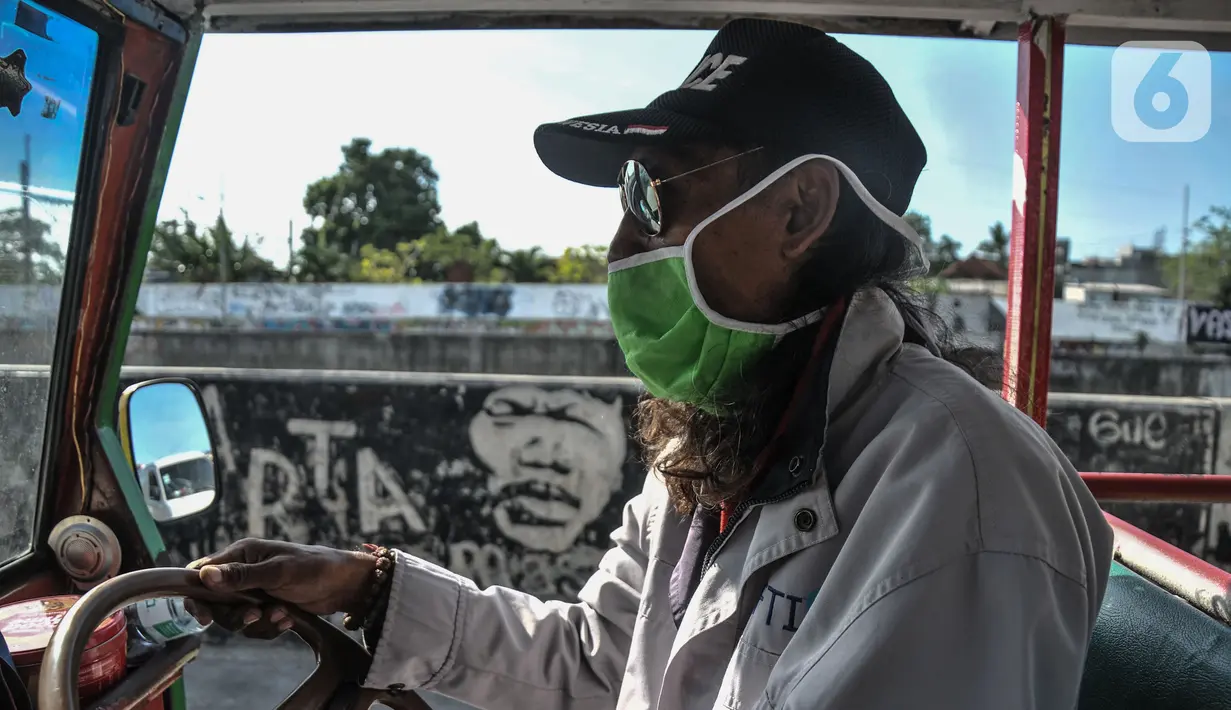 Gondrong (47) saat mengendarai odong-odong di Jalan Inspeksi Ciliwung, Jatinegara, Jakarta Timur, Senin (27/9/2021). Pandemi COVID-19 berdampak kepada pendapatan para sopir odong-odong yang menurun drastis. (merdeka.com/Iqbal S. Nugroho)