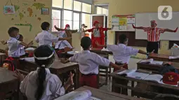 Seniman Aku Badut Indonesia (ABI) mengajak siswa berolahraga di SDN 03 Citayam, Kabupaten Bogor, Jawa Barat, Senin (6/9/2021). Aksi tersebut tentang protokol kesehatan serta membagikan masker kepada anak-anak sekolah yang menggelar Pembelajaran Tatap Muka (PTM). (Liputan6.com/Herman Zakharia)