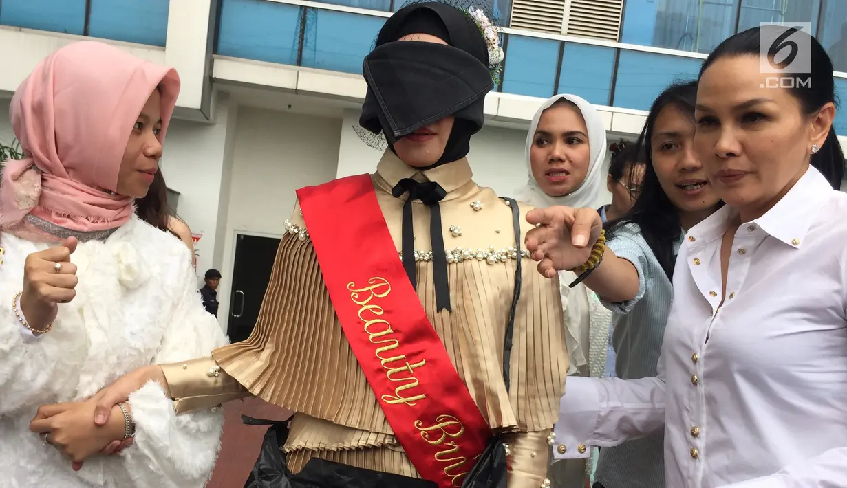 Aktris Angel Lelga ditutup matanya saat mengikuti rangkaian acara 'Bridal Shower' di Jakarta, Kamis (25/1). Dalam acara itu Angel Lelga mengalungi sebuah plastik hitam menyerupai tas, yang terdapat tulisan 'Hermes'. (Liputan6.com/Immanuel Antonius)
