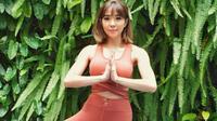Walaupun yoga di rumah, pakaian olahraga pun tetap harus menunjang. Gisel memilih mengenakan legging dan sport bra warna senada yang nyaman digunakan saat yoga atau workout. [Instagram/gisel_la]