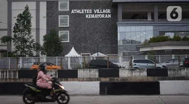 Pengendara motor melintas di depan Wisma Atlet, Kemayoran, Jakarta, Jumat (20/3/2020). Pemerintah akan mengubah fungsi Wisma Atlet Asian Games sebagai rumah sakit darurat khusus penanganan virus corona (Covid-19) sehingga bisa dipakai pada Senin (23/3/2020). (Liputan6.com/Immanuel Antonius)