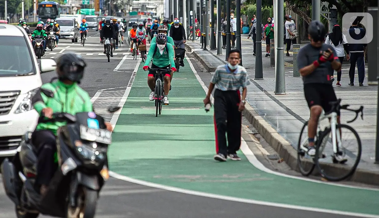 Sejumlah warga bersepeda di Bundaran HI, Jakarta, Minggu (2/1/2022). Meski hari bebas kendaraan bermotor atau car free day (CFD) ditiadakan, warga masih banyak yang beraktivitas di kawasan Sudirman-Thamrin. (Liputan6.com/Faizal Fanani)