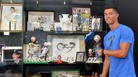 Cristiano Ronaldo memperlihatkan koleksinya di Museum CR7 di Funchal, Madeira, Portugal (23/7). Museum tersebut berisi perjalanan karier Ronaldo selama bertahun-tahun menggeluti dunia lapangan hijau. (AFP PHOTO/Helder Santos)