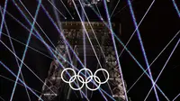 Pemandangan Menara Eiffel dan laser yang menerangi langit, selama upacara pembukaan Olimpiade Paris 2024, Jumat (26/7/2024). (Odd ANDERSEN / AFP)