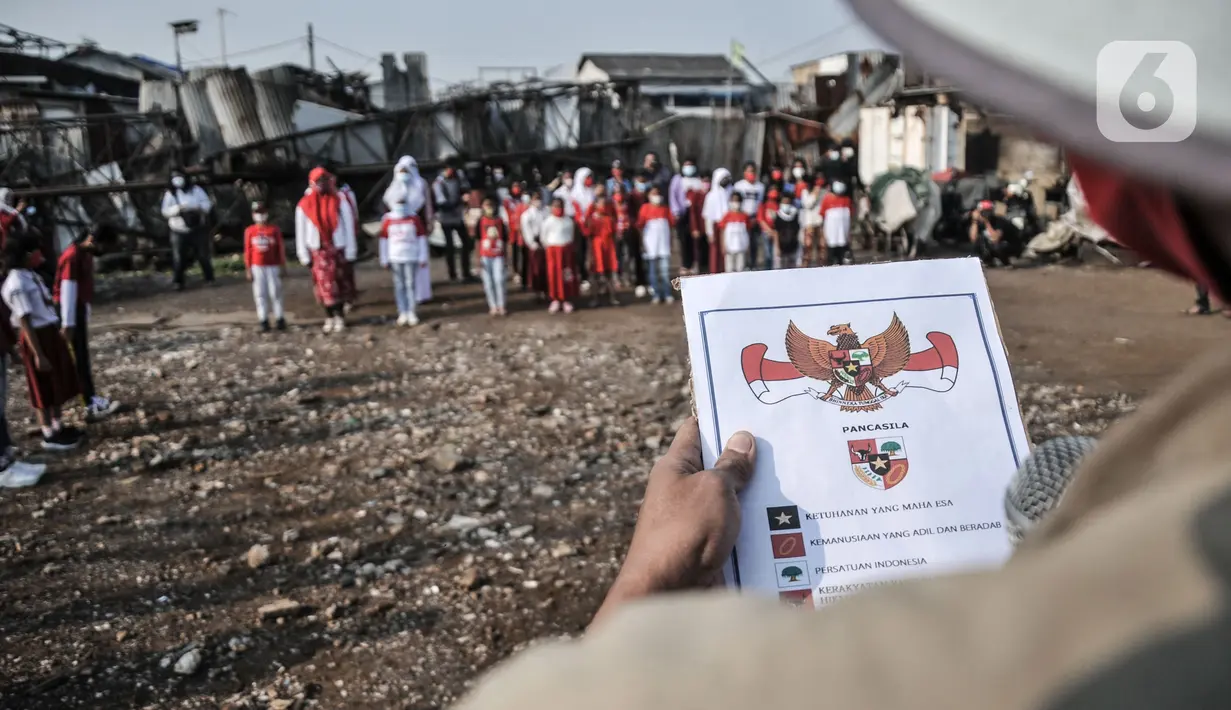 Pembina upacara saat membacakan Pancasila dalam upacara memperingati Hari Kemerdekaan ke-76 RI di Cilincing, Jakarta, Selasa (17/8/2021). HUT ke-76 RI diadakan secara sederhana dengan menerapkan protokol kesehatan. (merdeka.com/Iqbal S. Nugroho)