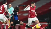 Gelandang Arsenal, Dani Ceballos (kanan) berebut bola dengan striker Crystal Palace, Wilfried Zaha dalam laga lanjutan Liga Inggris 2020/21 di Emirates Stadium, Kamis (14/1/2021). Arsenal bermain imbang 0-0 dengan Crystal Palace. (AFP/Neil Hall/Pool)