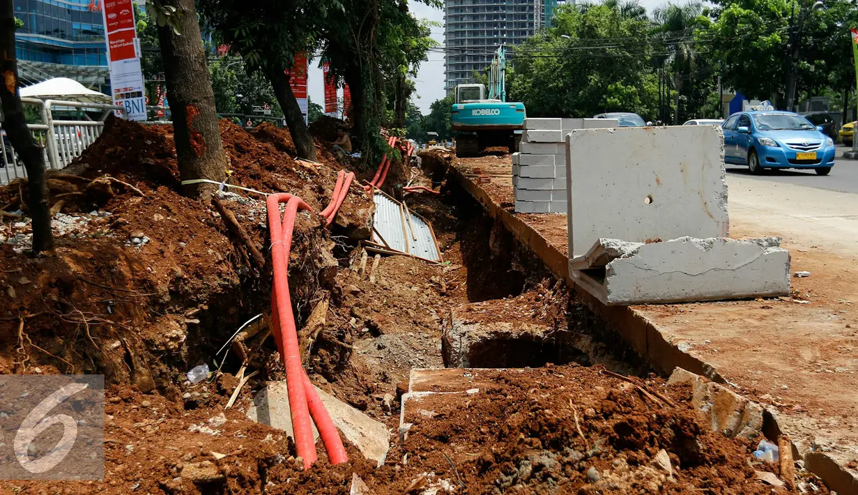 Sejumlah kendaraan melintasi disamping pembangunan jalan di Jakarta, Senin (23/11). Bila kualitas tidak sesuai standar maka Dinas Bina Marga tidak akan memberikan surat rekomendasi ke BPAKD untuk serah terima aset. (Liputan6.com/Yoppy Renato)