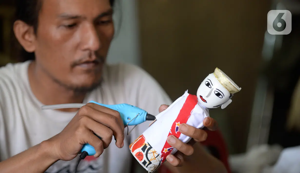 Pengrajin sedang menyelesaikan ondel-ondel hiasan yang terbuat dari limbah plastik botol di Kampung Sawah Lama, Ciputat, Tangerang Selatan, banten, Jumat (4/9/2020). Dalam satu hari perajin bisa menyelesaikan 30 biji kerajinan ondel-ondel budaya khas Betawi. (merdeka.com/Dwi Narwoko)