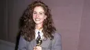 <p>Julia Roberts telah lama menjadikan jas sebagai ciri khasnya. Mungkin lebih dari 30 tahun, ia merupakan salah satu pengagum ansambel berkancing. Di Golden Globes 1990, Julia Roberts menerima kemenangan sebagai Aktris Pendukung untuk Steel Magnolias mengenakan setelan abu-abu berbahu tebal rancangan Giorgio Armani dan dasi bermotif biru laut. Foto: Vogue.</p>