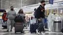 Wisatawan tiba untuk penerbangan di Bandara Internasional O'Hare di Chicago, Illinois pada 16 Maret 2021. Langkah vaksinasi COVID-19 di AS terus berlangsung hingga hari ini dan hal tersebut pun berdampak pada sektor perjalanan, termasuk perjalanan udara. (Scott Olson/Getty Images/AFP)
