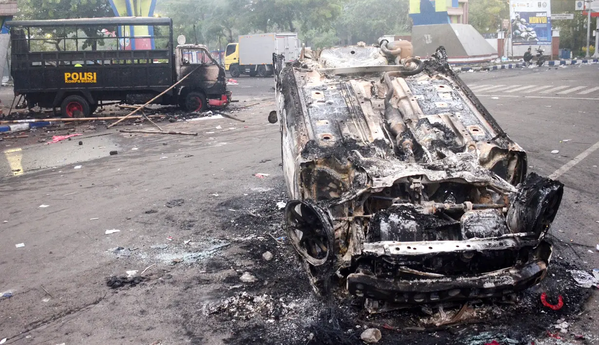 Sejumlah kendaraan dibakar di luar Stadion Kanjuruhan, Malang, Jawa Timur, Minggu (2/10/2022). Sebanyak 127 orang tewas ketika para penggemar yang marah menyerbu lapangan sepak bola setelah pertandingan antara Arema FC dan Persebaya Surabaya pada 1 Oktober 2022. (PUTRI/AFP)