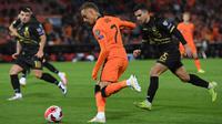 Pemain depan Belanda Noa Lang (depan) berebut bola dengan bek Gibraltar Julian Valarino pada laga Kualifikasi Piala Dunia 2022 zona Eropa Grup G di De Kuip, Rotterdam, Selasa (12/10/2021) dini hari WIB. Menjamu Gibraltar, Belanda menang 6 gol tanpa balas. (JOHN THYS/AFP)