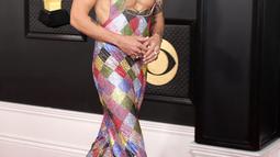 Penyanyi-penulis lagu Inggris, Harry Styles tiba untuk ajang Grammy Awards 2023 di Crypto.com Arena, Los Angeles, AS, Minggu Malam (6/2/2023) waktu setempat. Jumpsuit ini tak berlengan dan berpotongan dada rendah, sehingga menampilkan koleksi tato member One Direction. (Photo by Amy Sussman / GETTY IMAGES NORTH AMERICA / Getty Images via AFP)