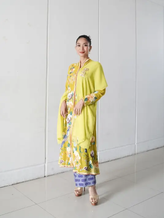 Happy Salma memilih kebaya panjang bernuansa kehijauan yang cantik dengan bordir flora di sepanjang kebaya. Ia padukan penampilannya ini dengan selendang hijau polos dan kain batik biru sebagai rok. [Instagram/happysalma]