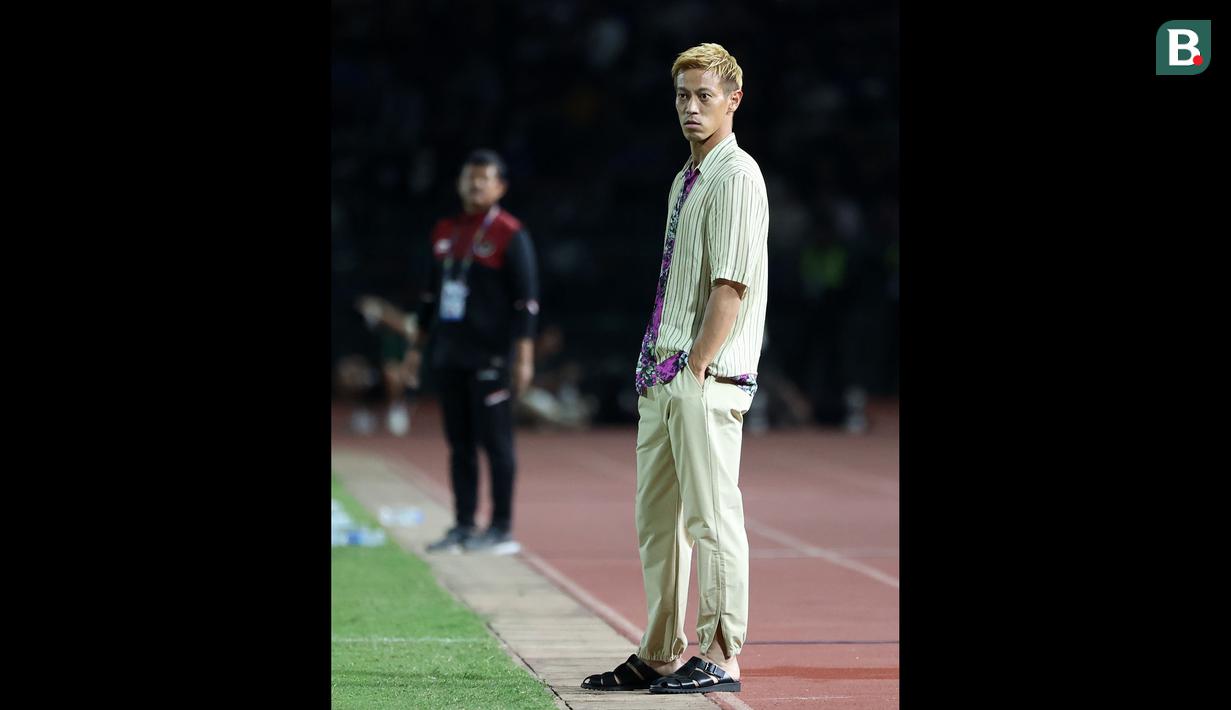 Pelatih Timnas Kamboja U-22, Keisuke Honda saat laga Grup A Sepak Bola SEA Games 2023 melawan Timnas Indonesia di Olympic National Stadium, Phnom Penh, Kamboja, Rabu (10/5/2023) malam WIB. Honda terkenal dengan gaya berpakaian unik saat mendampingi Kamboja pada perhelatan akbar olahraga di Asia Tenggara tersebut. (Bola.com/Abdul Aziz)