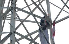 Pria berpakaian pocong di atas tower SUTET