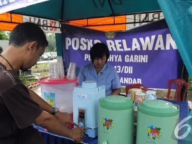Seorang wartawan mengambil kopi yang disuguhkan oleh Posko Relawan, Pangkalan Bun Kalimantan Tengah, Kamis (8/1/2015). (Liputan6.com/Andrian M Tunay)
