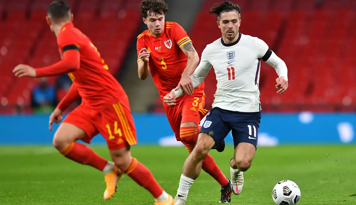 Gelandang Inggris, Jack Grealish, berebut bola dengan bek Wales, Neco Williams, pada laga persahabatan di Stadion Wembley, Jumat (9/10/2020) dini hari WIB. Inggris menang 3-0 atas Wales. (AFP/Glyn Kirk/pool)