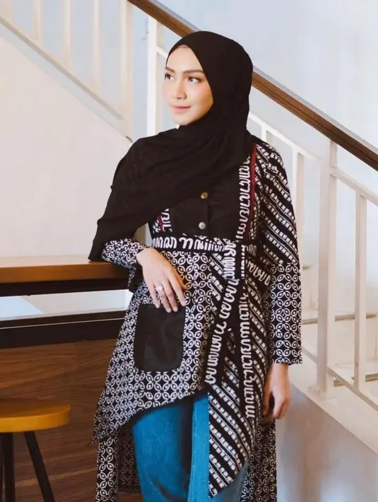 2. Atau bisa juga sontek gaya Melody Prima yang memadukan tunik batik asimetris dengan celana jeans dan pashmina warna hitam. (Instagram/melodyprima).