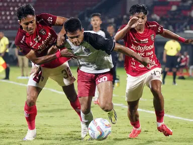 Pemain Persija Jakarta, Aji Kusuma (tengah) berebut bola dengan pemain Bali United, I Made Andhika Pradana Wijaya (kiri) dan Rahmat Arjuna Reski pada laga lanjutan Grup B Piala Presiden 2024 di Stadion I Wayan Dipta, Bali, Jumat (26/07/2024). (Dok. Persija Jakarta)