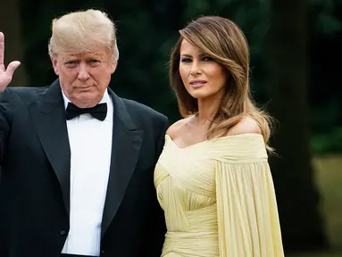 Presiden AS Donald Trump didampingi Ibu Negara, Melania Trump melambaikan tangan sesaat akan meninggalkan Winfield House di London, Kamis (12/7). Melania Trump dan Donald Trump tengah berada di Inggris untuk kunjungan kenegaraan.. (AFP/Brendan Smialowski)