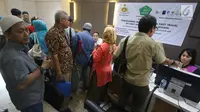 Petugas melayani Korban dugaan penipuan perjalanan umrah First Travel mengisi formulir di Posko Pengaduan Korban PT First Travel Bareskrim Polri, Jakarta, Senin (21/8). (Liputan6.com/Immanuel Antonius)