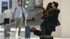 Natalia Abrahao diangkat tunangannya Mark Ogertsehnig saat mereka bertemu kembali di Bandara Internasional Newark Liberty di Newark, New Jersey, Senin (8/11/2021). AS membuka kembali perbatasannya mulai Senin untuk pengunjung asing, mengakhiri larangan masuk selama 20 bulan. (AP Photo/Seth Wenig)