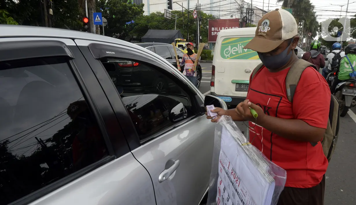 Pedagang menawarkan kalender tahun 2021 kepada pengguna jalan di perempatan Pondok Pinang, Kebayoran, Jakarta Selatan, Senin (7/12/2020). Jelang pergantian tahun, sejumlah pedangang mulai menjajakan kalender tahun 2021 dengan harga Rp 20 ribu-Rp 40 ribu tergantung ukuran. (merdeka.com/Dwi Narwoko)