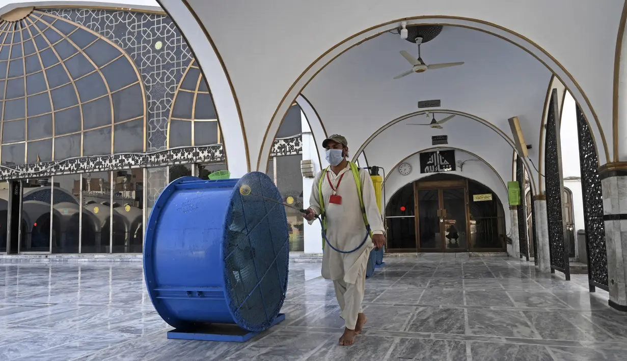 Seorang pekerja mendisinfeksi masjid Data Darbar menjelang Ramadan di Lahore, Pakistan pada Sabtu (10/4/2021). Kegiatan membersihkan masjid tersebut  untuk menyambut datangnya bulan suci Ramadan 1442 H. (Arif ALI / AFP)
