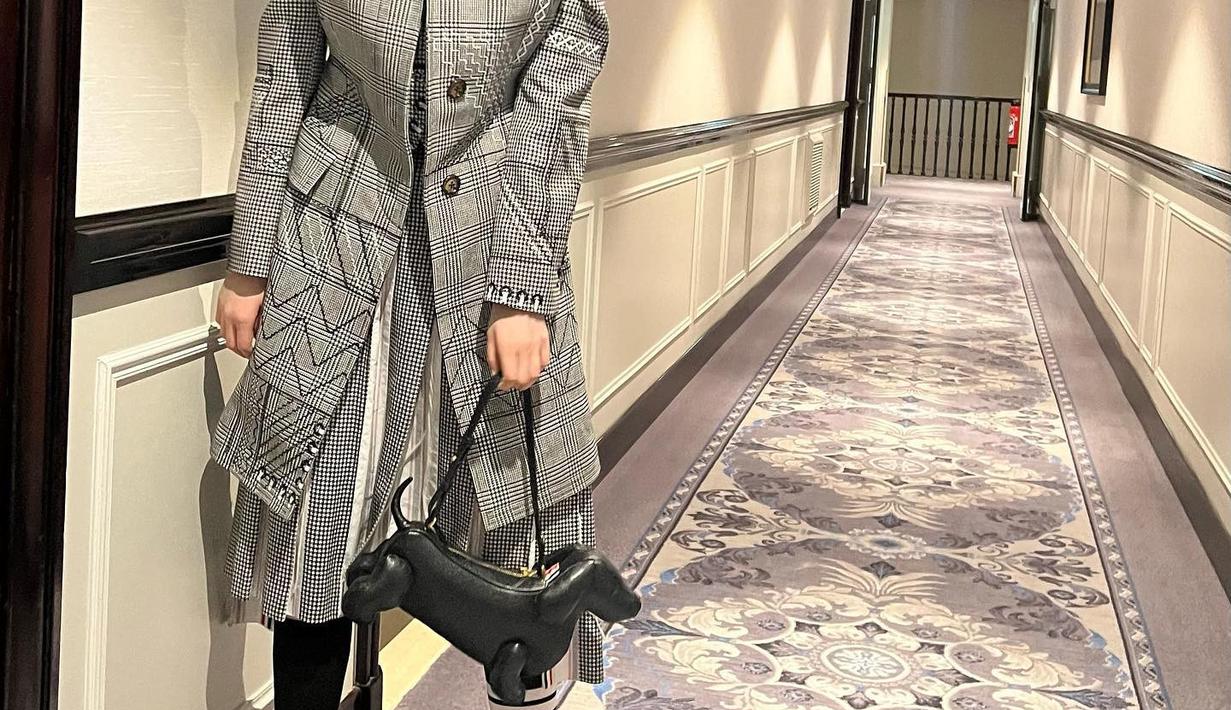 Dia memadukan bajunya dengan rok pleats potongan 7/8 dengan warna yang senada dengan bajunya. Model busana layering ini sangat cocok dengan postur tubuhnya yang tinggi.