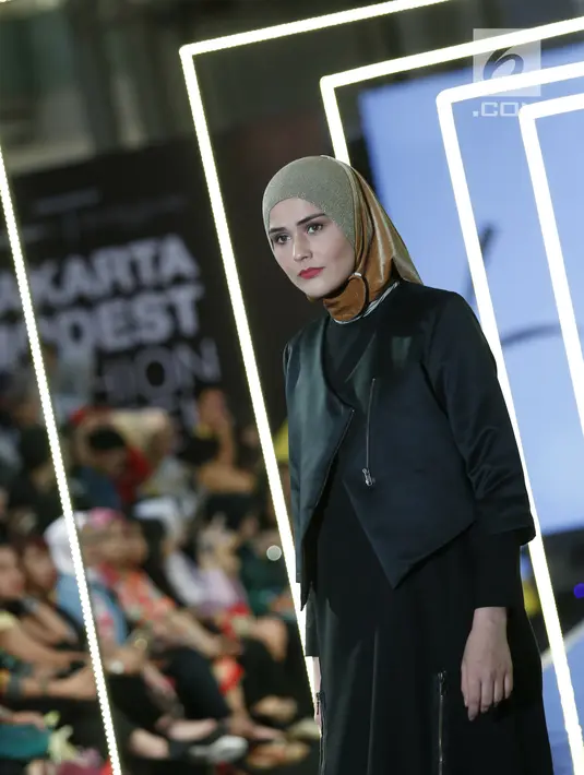 Model berpose mengenakan busana L.tru X Fenita Arie dalam ajang Jakarta Modest  Fashion Week, di Gandaria City, Jakarta, Jumat, (27/7). Sejumlah karya busana di ajang JMFW tersebut berlangsung hingga (29/7). (Kapanlagi.com/Agus Apriyanto)