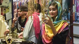 Seorang perempuan Pakistan memilih pernak-pernik di sebuah pasar di Lahore, Selasa (12/6). Umat muslim di berbagai penjuru dunia sedang mempersiapkan untuk merayakan Idul Fitri, yang menandai berakhirnya bulan suci Ramadan. (AFP/ARIF ALI)