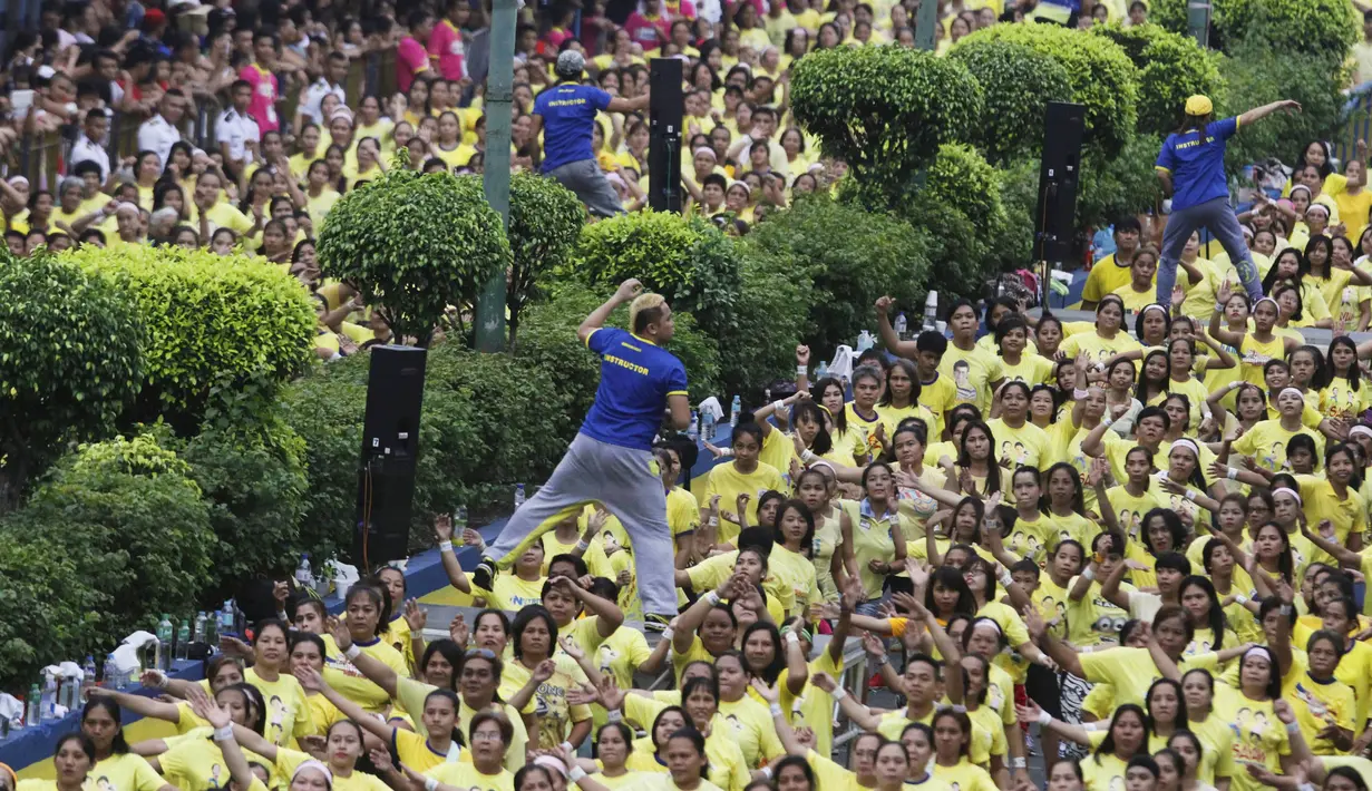 Sejumlah instruktur memimpin gerakan saat kelas zumba terbesar yang diadakan di sepanjang jalan utama Manila, Filipina, Minggu (19/7/2015). Acara ini diikuti hingga 12.975 peserta. (REUTERS/Lorgina Minguito) 