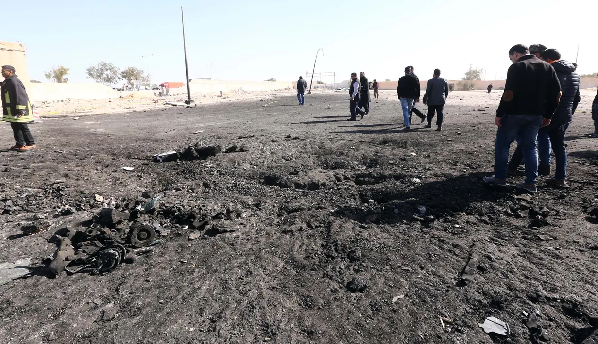 Sejumlah orang melihat  lokasi bom truk yang meledak di sekolah polisi di kota Zliten, wilayah barat Libya, Kamis (7/1). Belum ada yang mengaku bertanggung jawab terkait serangan bom yang menewaskan 50 orang tersebut. (AFP PHOTO/MAHMUD Turkia)