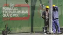 Seorang road crew bekerja di luar sirkuit corniche Formula One (F1), di Jeddah, Arab Saudi, Selasa (30/11/2021). Arab Saudi untuk pertama kalinya dipercaya menjadi tuan rumah balapan F1 2021, yang akan berlangsung 3-5 Desember mendatang. (AP Photo/Amr Nabil)