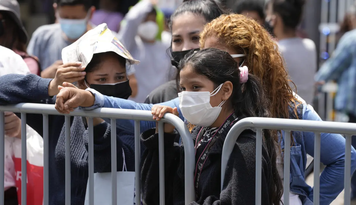 Orang-orang menunggu hasil tes PCR mereka untuk COVID-19 di sebuah pasar di Lima, Peru, Rabu (5/1/2022). Peru mengonfirmasi pada Selasa dimulainya gelombang ketiga infeksi virus corona di mana negara itu mencatat 309 kasus varian omicron yang sangat menular. (AP Photo/Martin Mejia)
