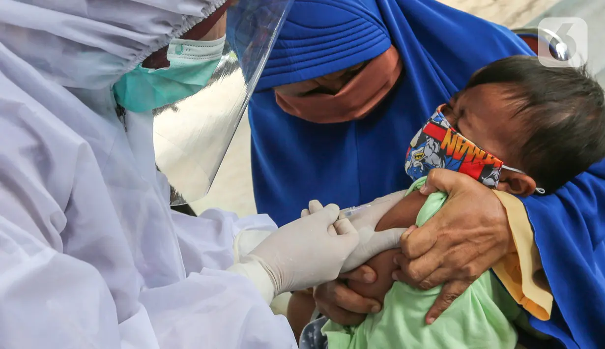 Bidan lengkap dengan baju Alat Pelindung Diri (APD) memberi imunisasi pada anak di Posko Imunisasi, Kelurahan Bakti Jaya, Tangerang Selatan, Senin (11/5/2020). Imunisasi sesuai jadwal akan membantu sistem imun anak memproduksi antibodi saat pandemi Covid-19. (Liputan6.com/Fery Pradolo)
