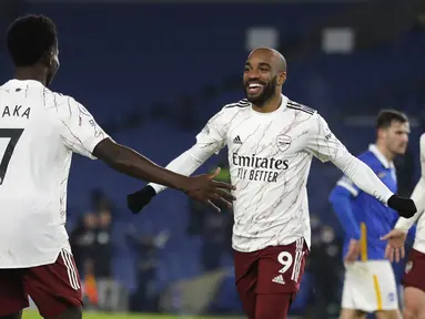 Penyerang Arsenal, Alexandre Lacazette (kanan) berselebrasi dengan rekan setimnya usai mencetak gol ke gawang Brighton & Hove Albion pada pertandingan lanjutan liga Inggris di stadion Falmer, Inggris, Rabu (30/12/2020). Meriam London menang tipis 1-0 atas Brighton. (AP Photo/Frank Augstein)