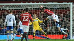 Bek MU, Chris Smalling berusaha menyundul bola ke arah gawang Wigan Athletic saat bertanding di Stadion Old Trafford, Inggris (29/1). Manchester United  melaju ke babak 16 besar Piala FA. (AP Photo/Rui Vieira)