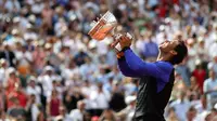 Petenis Spanyol, Rafael Nadal mengangkat trofinya usai mengalahkan Stan Wawrinka pada final Prancis Terbuka di Roland Garros, Minggu (11/6). Setelah dua tahun gagal juara, Nadal mengembalikan statusnya sebagai raja Prancis Terbuka (AP Photo/David Vincent)