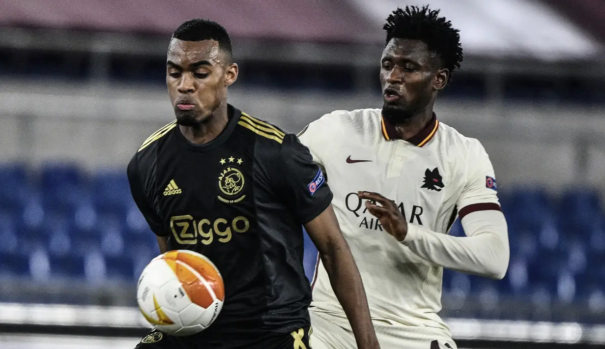 Gelandang Ajax Amsterdam, Ryan Gravenberch (kiri) menguasai bola dibayangi gelandang AS Roma, Amadou Diawara dalam laga leg kedua perempatfinal Liga Europa 2020/2021 di Olimpico Stadium, Roma, Kamis (15/4/2021). Ajax bermain imbang 1-1 dengan AS Roma. (AFP/Filippo Monteforte)