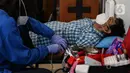 Petugas Palang Merah Indonesia (PMI) mengambil darah pendonor di Gereja Protestan Indonesia Bagian Barat (GPIB) Effatha, Jakarta, Sabtu (14/8/2020). Kegiatan donor darah merupakan agenda rutin yang sempat terhenti akibat pandemi Covid-19. (Liputan6.com/Johan Tallo)