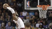 Bintang Cleveland Cavaliers LeBron James melakukan slam dunk pada lanjutan NBA 2017-2018 melawan Charlotte Hornets di Spectrum Center, Rabu (28/3/2018) atau Kamis (29/3/2018) WIB. (AP Photo/Chuck Burton)