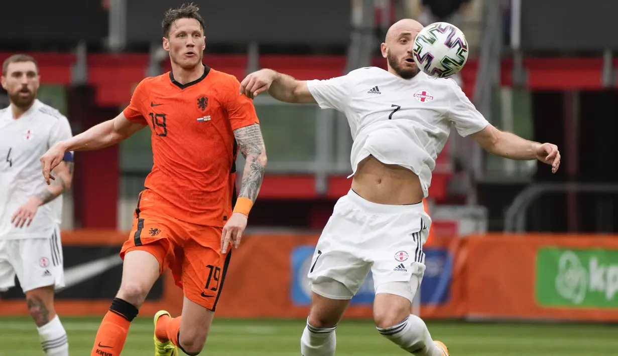 Gelandang timnas Georgia, Valerian Gvilia mengontrol bola dibayangi penyerang timnas Belanda, Wout Weghorst dalam pertandingan uji coba jelang Piala Eropa 2020 di De Grolsch Veste, Minggu (6/6/2021). Belanda menang meyakinkan 3-0. (AP Photo/Peter Dejong)